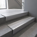 Aluminium stair nosing 90x32mm double channel fitted to a concrete step - Satin Aluminium finish with twin Polar Grey Smooth Textured inserts