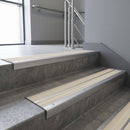 Aluminium stair nosing 90x32mm double channel fitted to a concrete step - Satin Aluminium finish with twin Porth Stone Castellated inserts