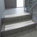 Aluminium stair nosing 90x32mm double channel fitted to a concrete step - Satin Aluminium finish with twin White Castellated inserts
