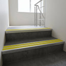 Aluminium stair nosing 90x32mm double channel fitted to a concrete step - Satin Aluminium finish with twin Yellow Castellated inserts