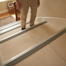 Heavy-duty stair nosing Jumbo on stone tile stairs with elderly person safely descending using handrail UK
