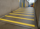 Yellow GRP anti-slip strips on external ramp — DDA high-visibility permanent grip
