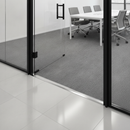 Aluminium T-bar threshold strip installed at UK office doorway bridging tiles to carpet tiles