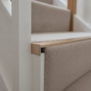 Champagne anodised aluminium stair nosing end cap fitted to a carpeted staircase edge in a UK home hallway