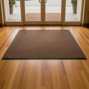 Brown mix heavy duty entrance barrier mat laid at a hotel lobby entrance on warm wood flooring
