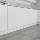 White vinyl skirting board trim at base of kitchen units meeting tile floor