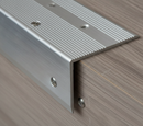 Close-up of surface mount aluminium step nosing showing anti-slip grooves and countersunk screws on laminate stair