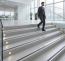 DDA compliant stair nosing on modern UK office building staircase - businessperson descending with clear step edge visibility