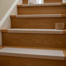 Clear anti-slip tape on oak wooden stair step — invisible grip preserving wood appearance