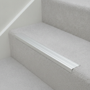Matt Silver NAS stair nosing on light grey carpet staircase in modern UK residential property