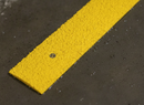 Close-up of GRP non-slip strip impregnated quartz grit surface — permanent anti-slip texture