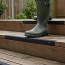 Anti-slip GRP decking strip installed on wooden garden decking steps, shown in real-life use with a wellington boot stepping onto the grip strip