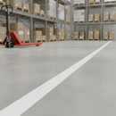 White PVC floor marking tape line applied on a warehouse floor, with racking and a pallet truck in the background