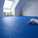 Blue diamond-plate interlocking EVA foam floor tiles fitted in a bright loft yoga and pilates space