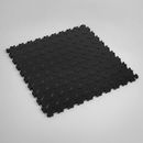 Black diamond-plate PVC interlocking garage floor tile on studio background showing raised tread texture