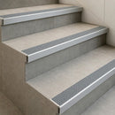 Tile-in stair nosings with grey anti-slip inserts set flush into grey tiled steps