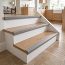 Grey self-adhesive PVC bullnose stair nosing 50x25mm fitted to light oak steps into a kitchen