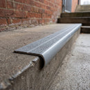 Bullnose aluminium stair nosing 98x40mm with twin Grey / Grey gritted GRP inserts, fitted to a concrete step at a covered walkway in a school