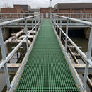 Green GRP open mesh grating forming an elevated walkway at a UK water treatment works