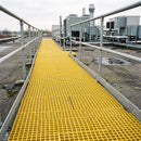 Yellow GRP grating panels forming a roof access walkway between handrails at a UK industrial site