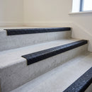 Black GRP stair nosings fitted to a concrete stair flight in a commercial building