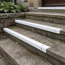 White GRP stair nosings fitted over external stone steps, capping each step edge