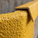Macro close-up of the coarse gritted anti-slip surface and chamfered back edge of the GRP nosing