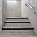 Black GRP stair nosings on the concrete stair core of a multi-storey car park
