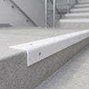 White GRP stair nosing fitted over a concrete step edge in a hospital stairwell