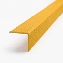 End-on view of a yellow GRP stair nosing showing the right-angled cross-section and ceramic grit