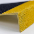 Close-up of the gritted anti-slip surface and yellow nosing edge of a GRP stair tread cover