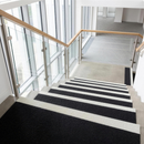 Black anti-slip GRP stair tread covers with white nosing fitted to indoor office stairs