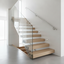 Brushed chrome wall-mounted stair handrail installed on a contemporary staircase wall
