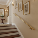 Satin brass wall-mounted stair handrail installed in an elegant hallway staircase
