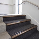 Heavy duty bullnose aluminium stair nosing with black insert in dark bronze finish fitted on an office stairwell with charcoal contract carpet