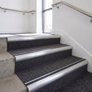 Heavy duty bullnose aluminium stair nosing with black insert in mill finish finish fitted on an office stairwell with charcoal contract carpet