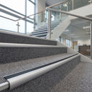 Black insert bullnose carpet stair nosings fitted along grey carpeted office stairs