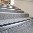Blue insert carpet stair nosings on a light grey carpeted communal stairway