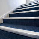 White insert carpet stair nosings fitted along a navy carpeted communal stairwell