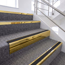 Mirrorflect gold chevron stair nosing with black insert fitted on grey carpeted stairs