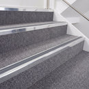 Bright polished double insert chevron stair nosing with dark grey inserts fitted on carpeted stairs