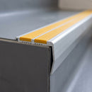 Close-up of the double insert chevron stair nosing end showing the flush inserts and angled riser face