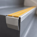 Close-up of the double insert chevron stair nosing end showing the flush inserts and angled riser face