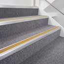 Mill finish double insert chevron stair nosing with yellow inserts fitted on grey carpeted stairs