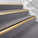 Satin gold double insert chevron stair nosing with black inserts fitted on grey carpeted stairs