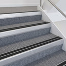 Satin silver double insert chevron stair nosing with black inserts fitted on grey carpeted office stairs