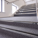 Aluminium Stair Nosing 2.75m Rake Back Single Insert Strip in Mirrorflect Silver finish fitted on a commercial stair