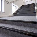 Heavy duty rake back aluminium stair nosing with black insert in satin black finish fitted on a stair with grey contract carpet