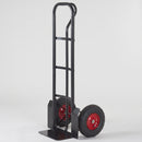 Black heavy duty steel sack truck with P handle, two 300mm pneumatic tyres on red steel rims and a wide black toe plate, standing upright on a plain light grey studio background