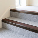 Dark bronze aluminium stair nosing with Brown insert fitted to pale silver-grey carpet on a hotel landing stair
